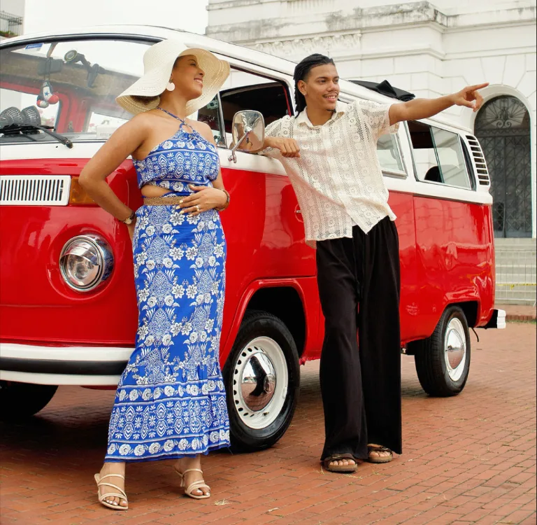 Guest in blue dress beside a classic red VW Kombi in Casco Viejo
