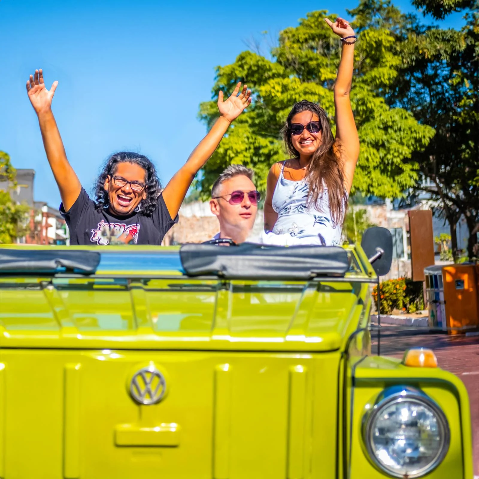 Happy guests in a green VW Safari on a sunny day